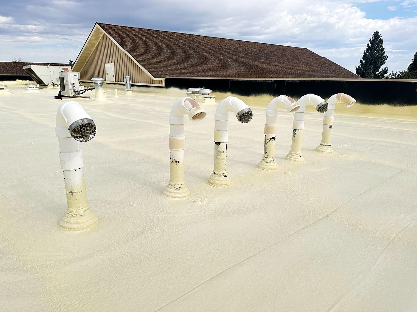 Freshly coated roof vents and pipe penetrations