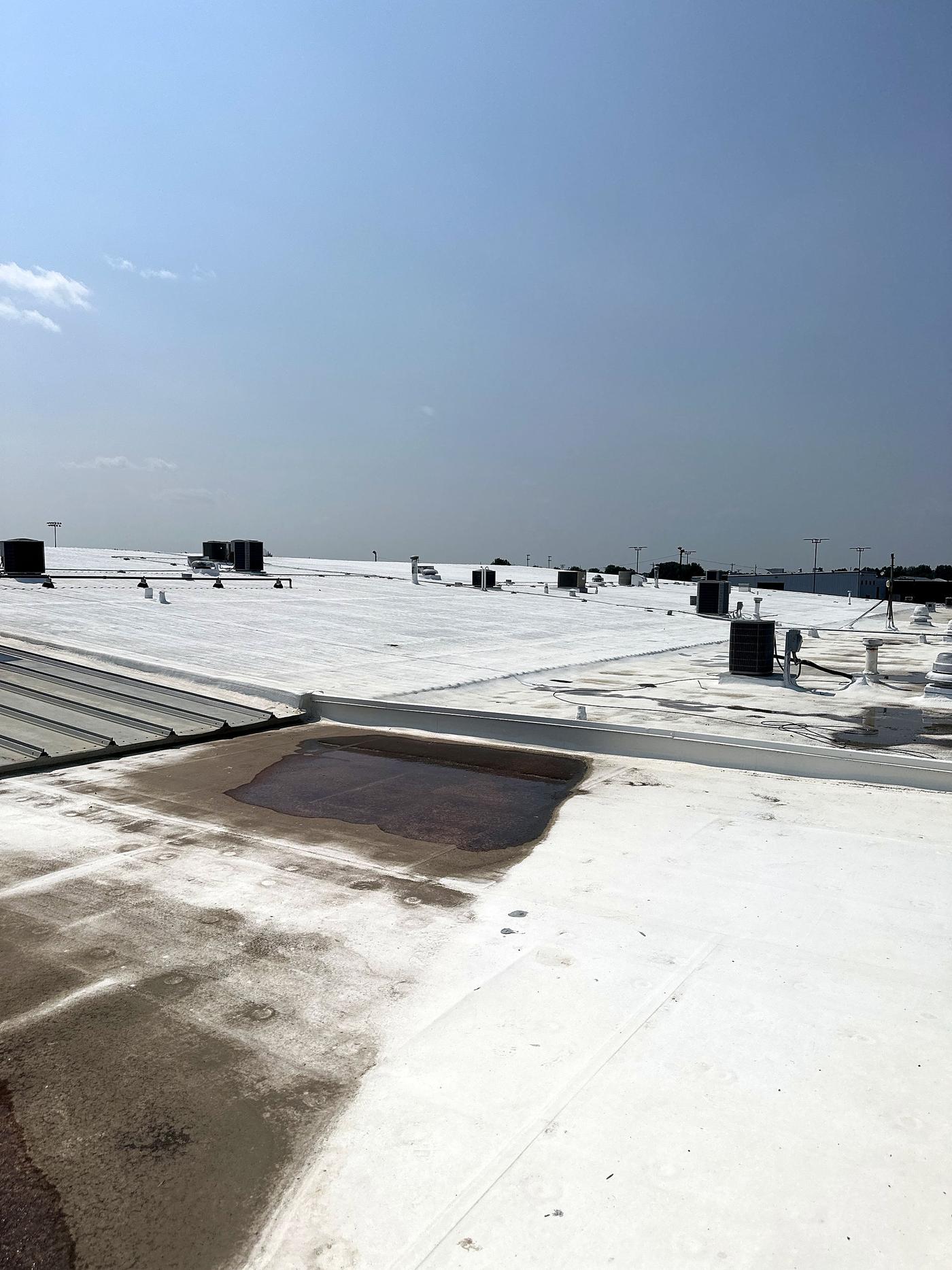 Aged flat roof surface with darker worn areas (inspection, Jul 2023)