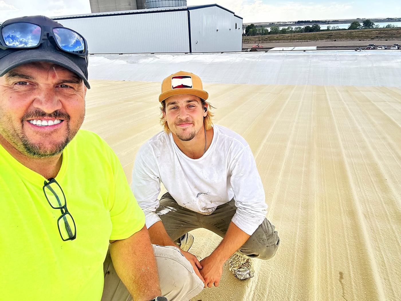 Sam Hostetler, owner of Revive Commercial Roofing, with his son Ben on a freshly coated roof